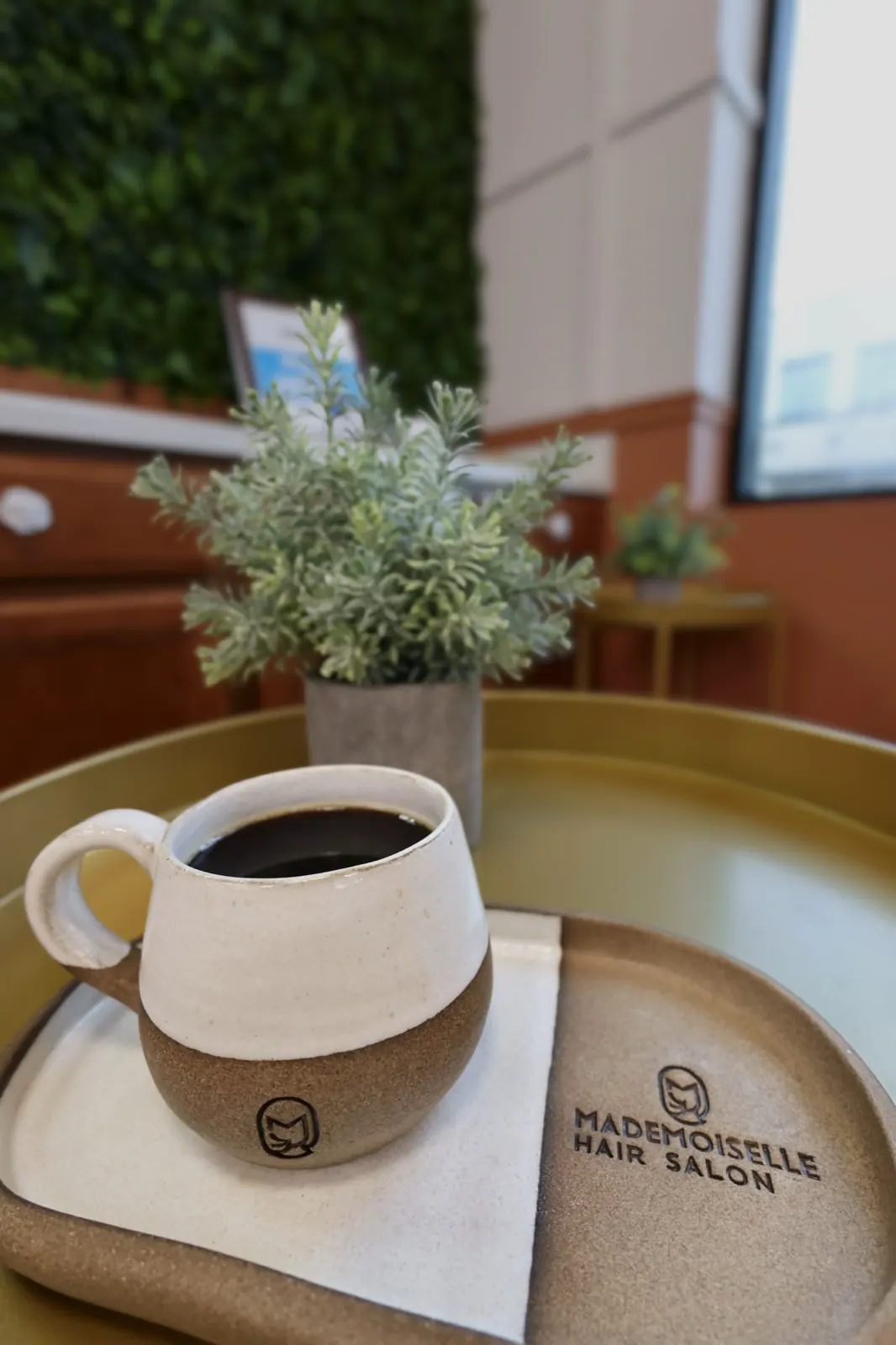 Coffee cup on a Mademoiselle Hair Salon branded tray